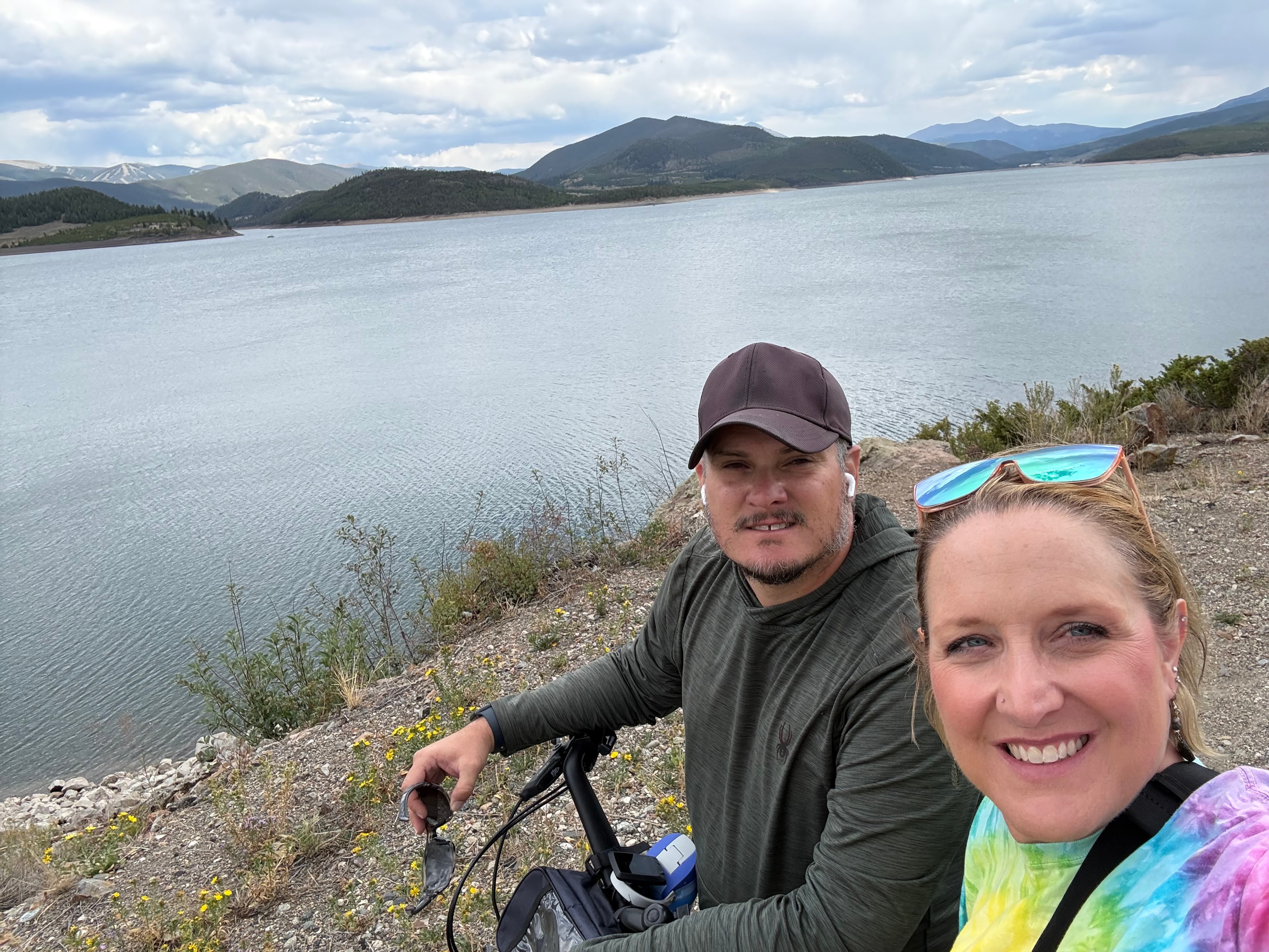 David Onori and his wife on a bike ride beside a mountain lake