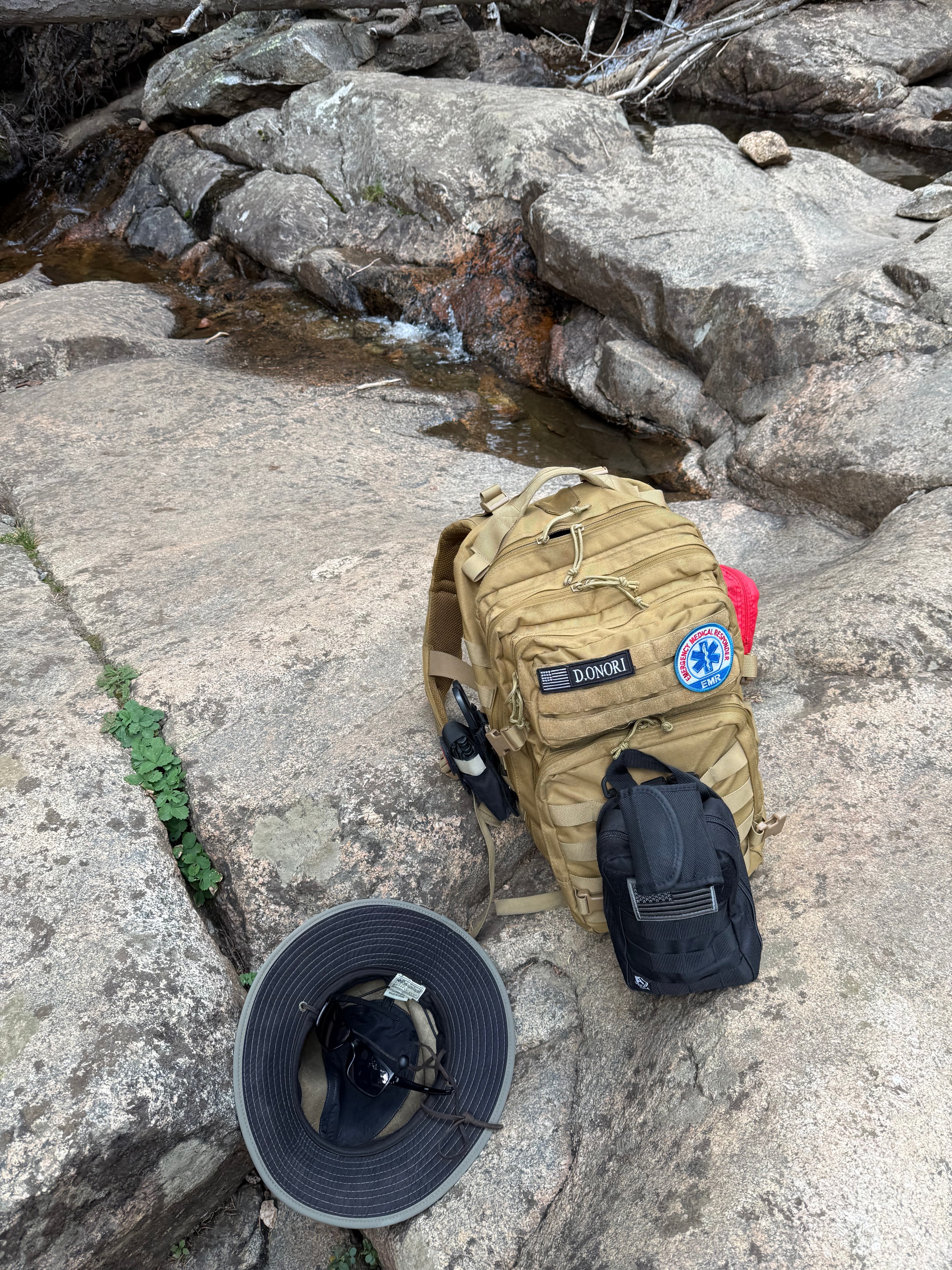 David Onori's hiking gear beside a mountain stream during a hike