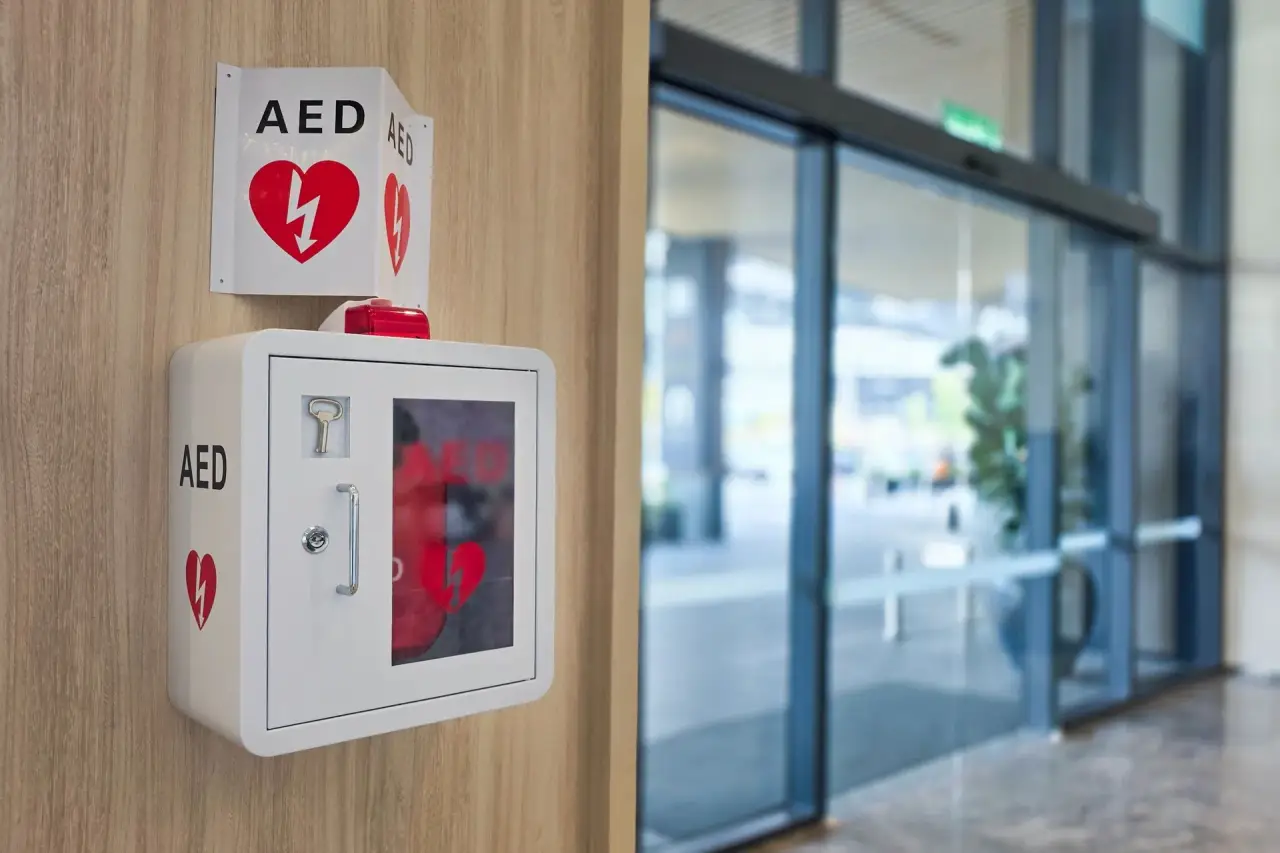 AED unit mounted in a wooden wall cabinet.