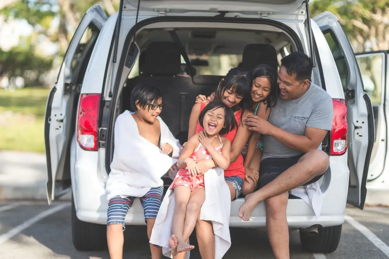 Children laughing in the back of a vehicle/tailgate (family scene).